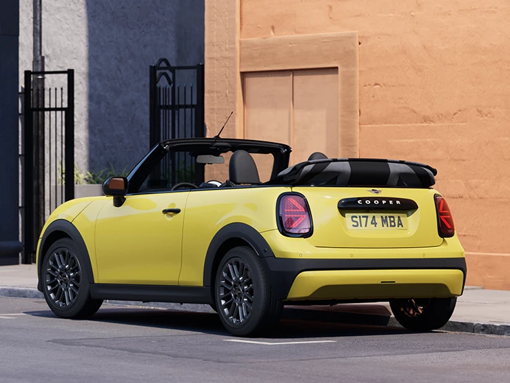 後左視角Sunnyside Yellow車色的 MINI Cooper敞篷車停車中。