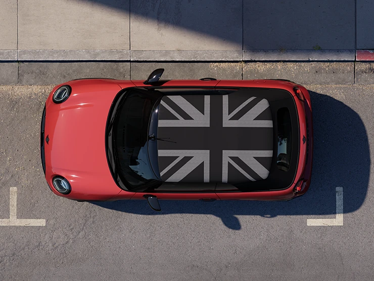 俯瞰Chili Red車色的MINI Cooper敞篷車搭配MINI專屬車頂，停靠在街道上。