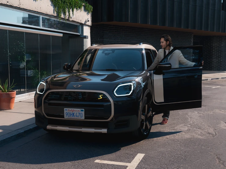 全電動MINI Countryman（Midnight Black車色搭配Vibrant Silver車頂）街景前視圖。