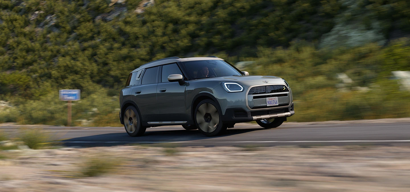 駕駛純電MINI Countryman（搭配Vibrant Silver車頂）的側面越野行駛畫面。