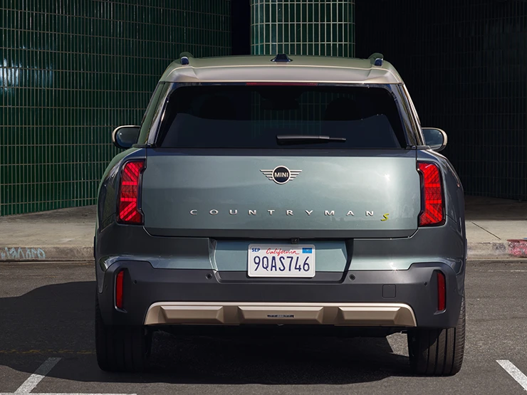 純電MINI Countryman（Smokey Green車色搭配Vibrant Silver車頂）停車狀態後視圖。